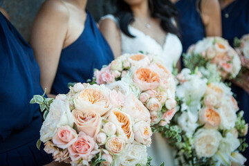 bride and bridesmaids holding bouquet of flowers