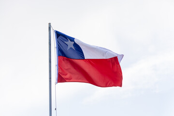 Fototapeta na wymiar Bandera Chilena flameando al viento en un cielo nublado