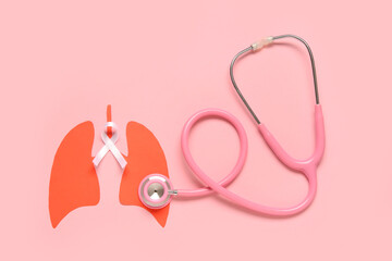 Paper lungs with white ribbon and stethoscope on pink background. Lung cancer concept