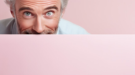 text space for advertising with funny part as portrait of a aged male model with gray hair peeking over a colored panal