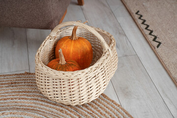 Wicker basket with Halloween pumpkins in living room