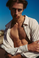 model guy posing on the sand on the beach by the sea