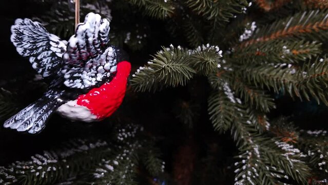Toy bullfinch bird on the Christmas tree in motion