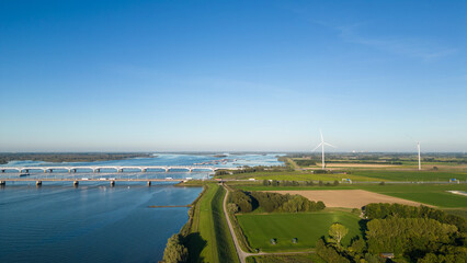 Aerial drone shot of Moerdijk bridge in the Netherlands or in Dutch, moerdijkbrug, crosses the Hollands Diep river on sunny summer day. Traffic flows across the wide stretch of fresh water 