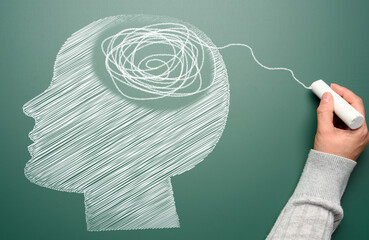  Profile of a human head with a tangled spiral in the brain area. The head is drawn in white chalk....