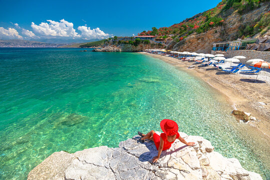 Pulebardha Beach in Albania provides the perfect setting for unwinding, swimming, and immersing yourself in breathtaking surroundings. Woman enjoying beautiful beach view from above a cliff.