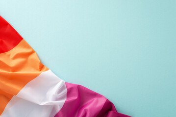 Embrace International Lesbian Day with a top view shot showcasing a Lesbian Pride flag against a pastel blue backdrop, perfect for adding your message