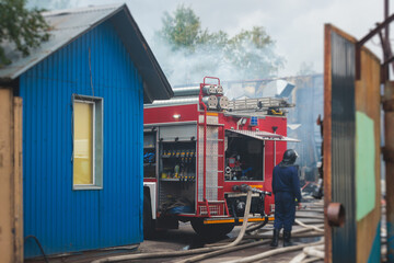 Group of fire men in protective uniform during fire fighting operation in the city streets,...