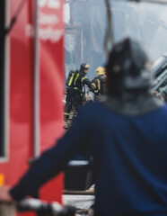 Group of fire men in protective uniform during fire fighting operation in the city streets,...