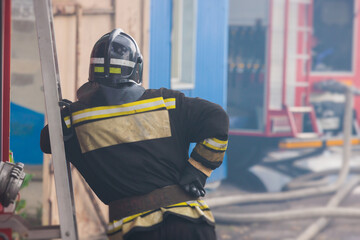 Group of fire men in protective uniform during fire fighting operation in the city streets,...