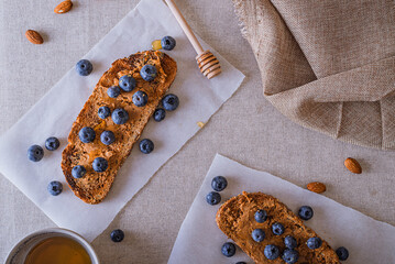 Breakfast of toasts with blueberries, peanut butter and honey