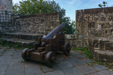 Antique cannon artillery defensive weapon at historic fort building Castillo de la Mota on Mount...