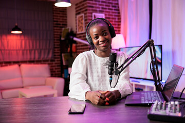 Portrait of african american content creator broadcasting live on streaming platform using professional camera producing high quality output. Woman creating content for social media websites