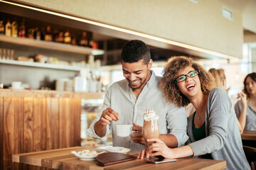 Young African American couple having coffee on a date in a cafe