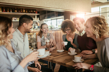 Young and diverse group of people talking and having coffee together in a cafe