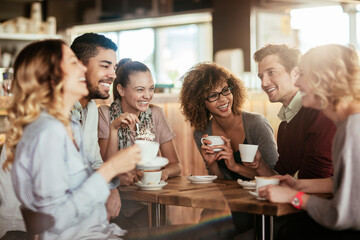 Young and diverse group of people talking and having coffee together in a cafe - Powered by Adobe