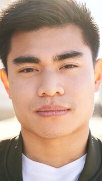 Outdoor Vertical portrait of an Asian man looking at the camera with a serious face and intense look. Close up of a serene human face - Concept of real people and emotions. High quality photo