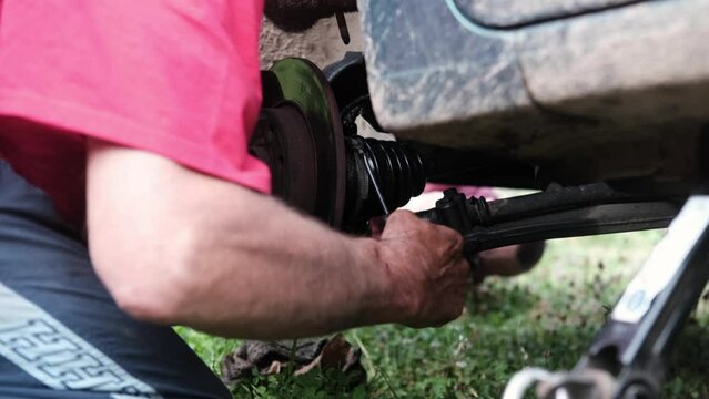 car repair. Close-up of a man's hands with a screwdriver repairing a car disk.