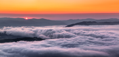 Panorama with amazing sunrise. Landscape with high mountains. Morning fog and dew. Touristic resort...