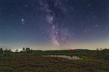 Meteor and the Milky Way over the Black Moor located in the Rhoen Biosphere Reserve in Germany.