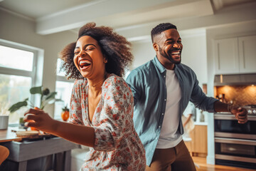 Beautiful young african american couple dancing to music and having the time of their lives in living room