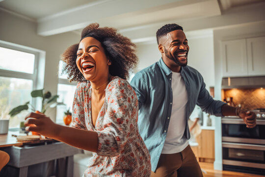 Beautiful young african american couple dancing to music and having the time of their lives in living room - Powered by Adobe