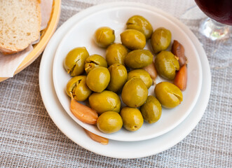Small healthy snack - few handful of pickled green pitted olives and slice of bran bread