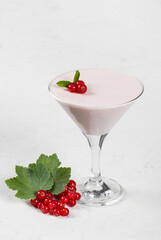 Red currant cream jelly, Panna Cotta, in a martini glass. White background. Copy space