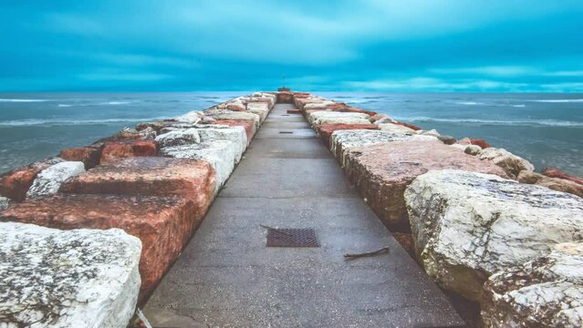 Timelapse, dam on the sea, in the day with waves
