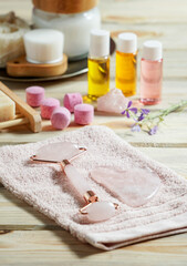 Jade face rollers and Gua sha stones for beauty facial massage therapy, Items for home treatment with skin care anti-aging tools, oils and moisturiser cream