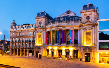Illuminated opera house in Antwerp at dusk. Antwerpen opera building decorated with LGBT flags and multicolored columns.