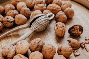 Shelled walnuts and a silver nutcracker in a round metal bowl on a wooden table. Healthy food and snacks.Healthy fats. Keto diet ingredient. Nuts and seeds. Useful healthy snack.