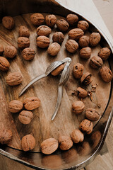 Shelled walnuts and a silver nutcracker in a metal bowl on a wooden table. Healthy food and snacks.Healthy fats. Keto diet ingredient. Nuts and seeds. 