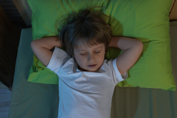 Little boy snoring while sleeping in bed at night, top view