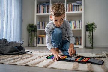 Small boy pupil child prepare his backpack for first day of school