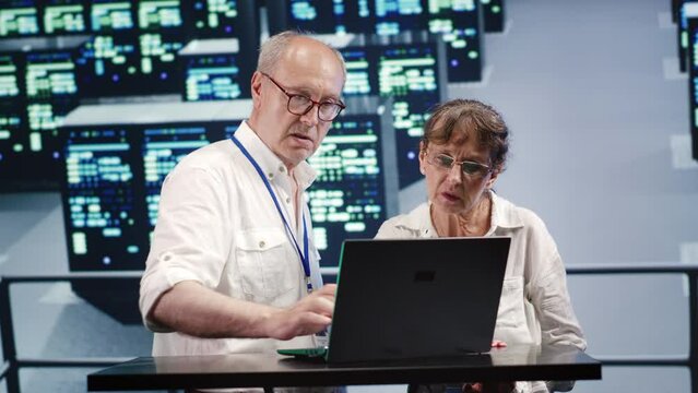 Octogenarian employees looking around innovative server hub, preparing to start comission on malfunctioning high tech space hardware cabinets in order to ensure smooth operations