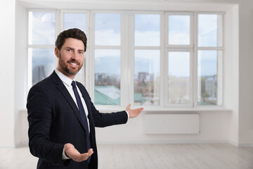 Fototapeta premium Happy real estate agent showing new apartment. Space for text