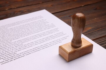 One stamp tool and document on wooden table, closeup