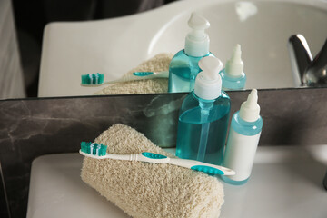 Light blue toothbrush, terry towel and cosmetic products in bathroom