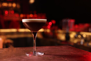 Glass of delicious Espresso Martini on bar counter, space for text. Alcoholic cocktail