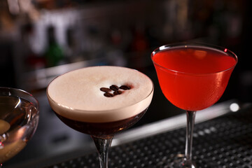 Glasses of different Martini cocktails on bar counter, closeup