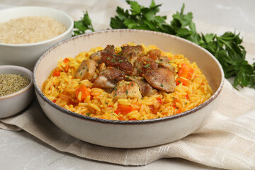 Delicious pilaf with meat and ingredients on light grey table, closeup
