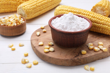 Bowl with corn starch and kernels on white wooden table
