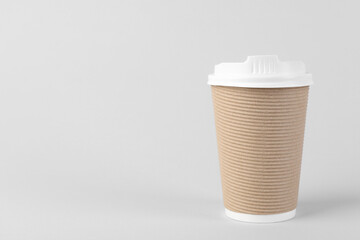 Paper cup with plastic lid on light background, space for text. Coffee to go