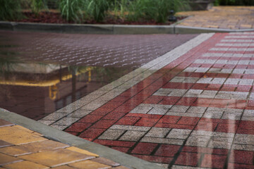 Puddle after rain on street tiles outdoors
