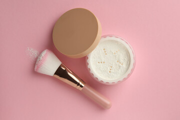 Rice loose face powder and makeup brush on pink background, flat lay