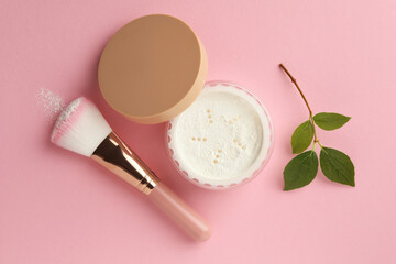 Rice loose face powder, makeup brush and branch on pink background, flat lay