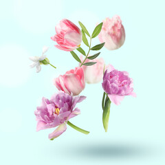 Beautiful flowers and green leaves falling on pastel turquoise background