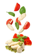 Making Caprese salad. Fresh tomatoes. mozzarella cheese and basil leaves falling against white background