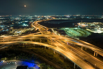 Fototapeta na wymiar Aerial view of american freeway intersection at night with fast driving cars and trucks in Tampa, Florida. View from above of USA transportation infrastructure